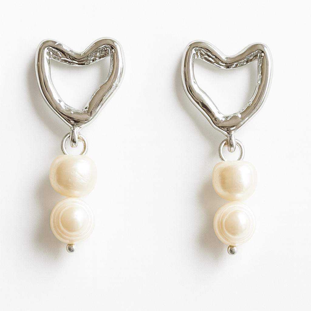 Pair of earrings with heart-shaped top and pearl drop on a white background