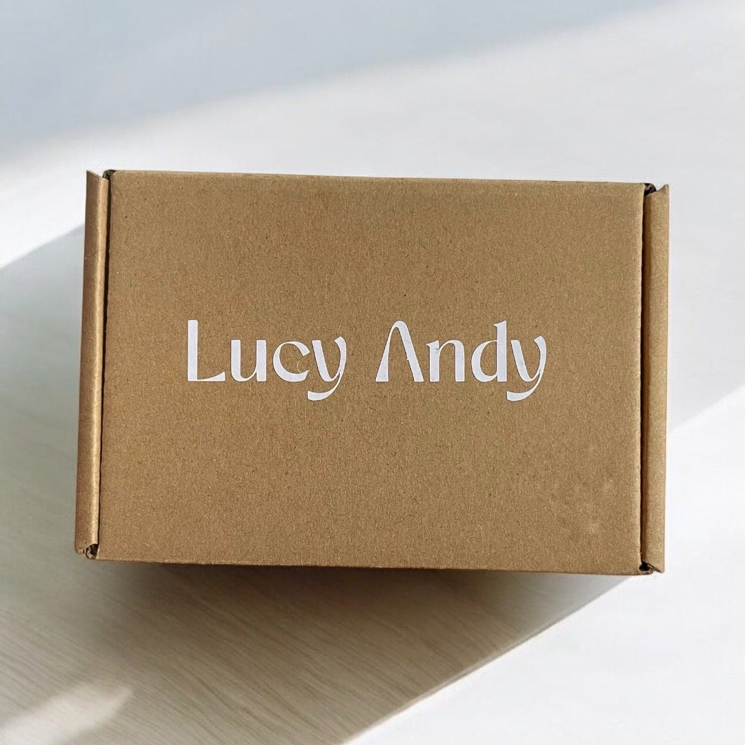 Brown box with 'Lucy Andy' branding on a light wooden surface