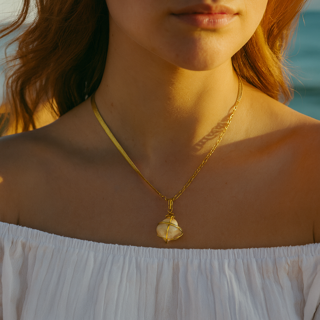 Woman wearing a gold necklace with a pendant against a blurred natural background
