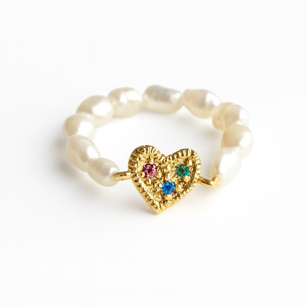 Gold heart-shaped ring with colored stones on a white background