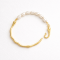 Gold bracelet with pearl beads on a white background