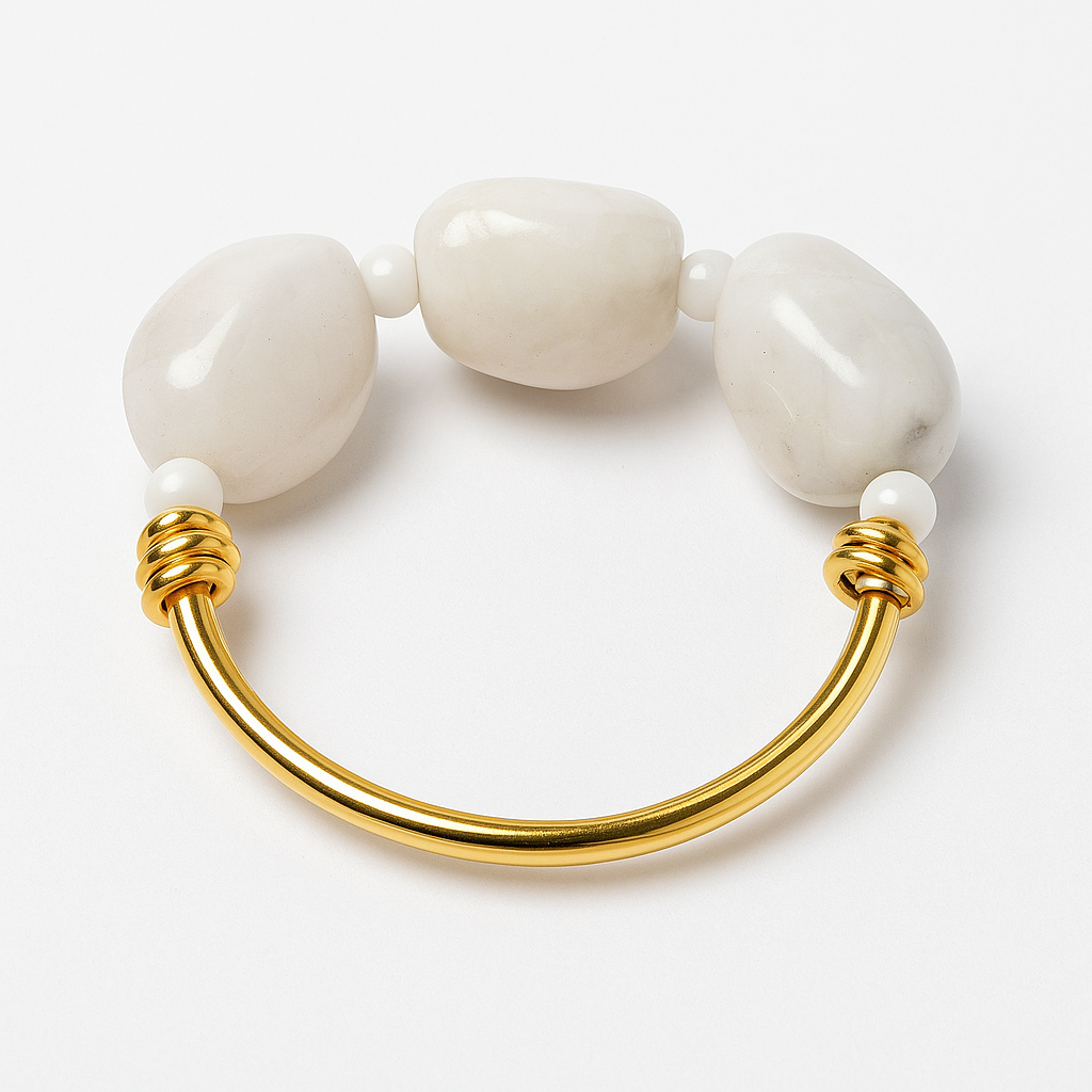 Bracelet with gold clasp and white beads on a light background