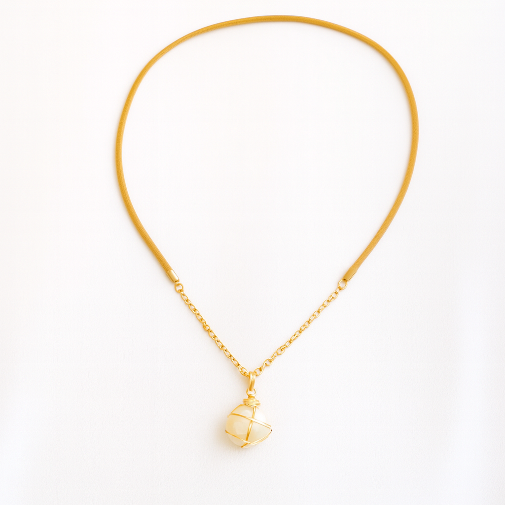 Gold necklace with a small pendant on a white background