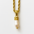 Gold necklace with a pearl pendant on a white background