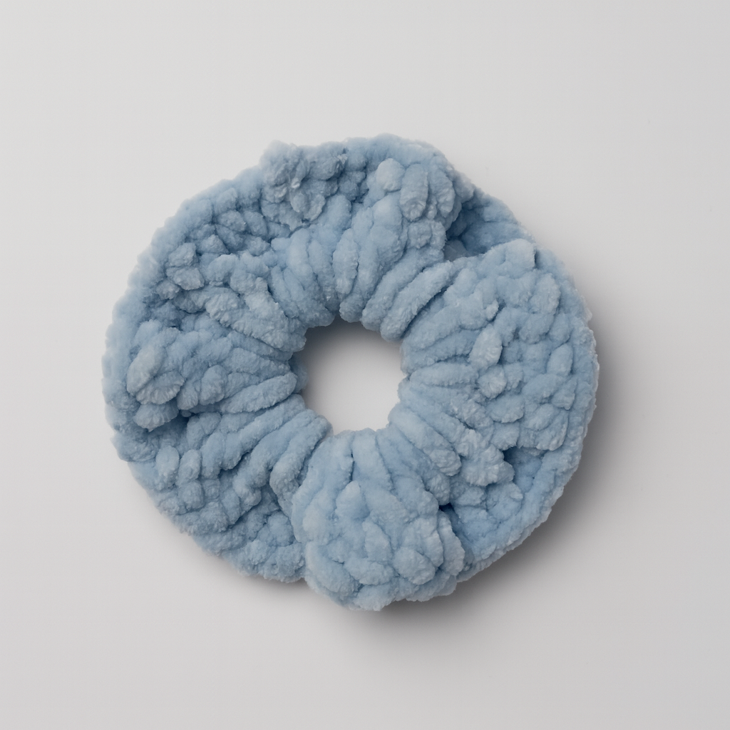 Blue fluffy scrunchie on a light gray background
