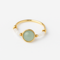 Gold ring with a green gemstone on a white background
