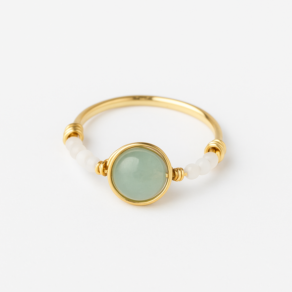 Gold ring with a green gemstone on a white background