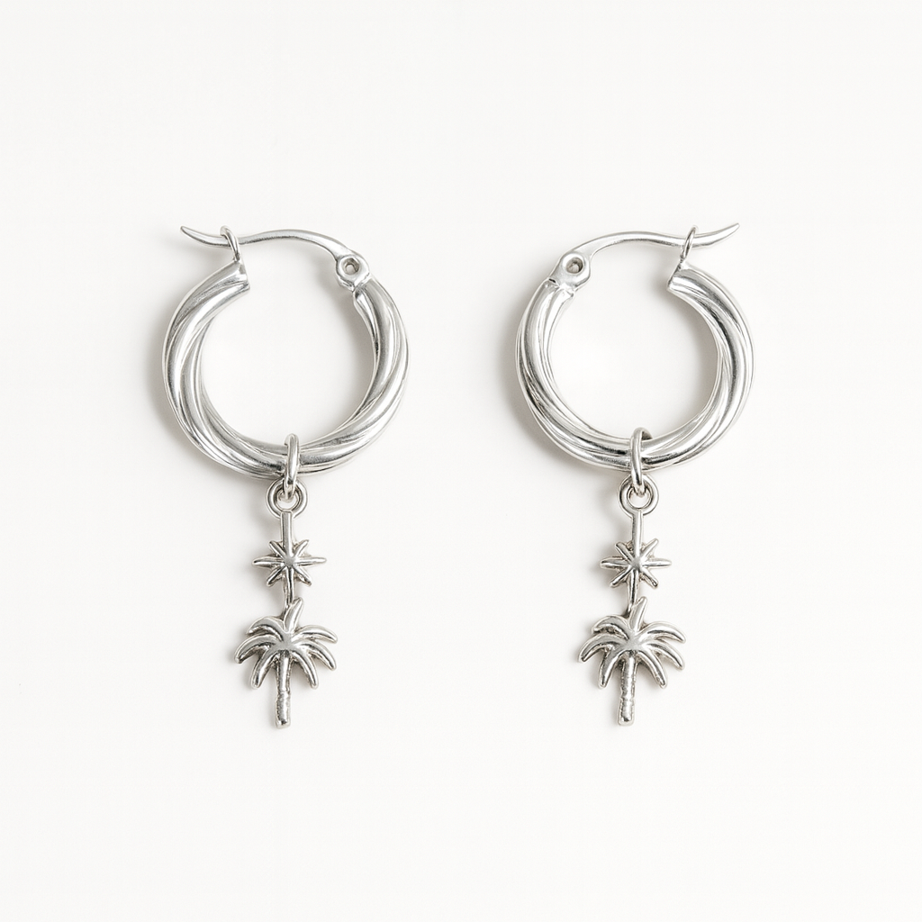 Silver hoop earrings with palm tree charms on a white background