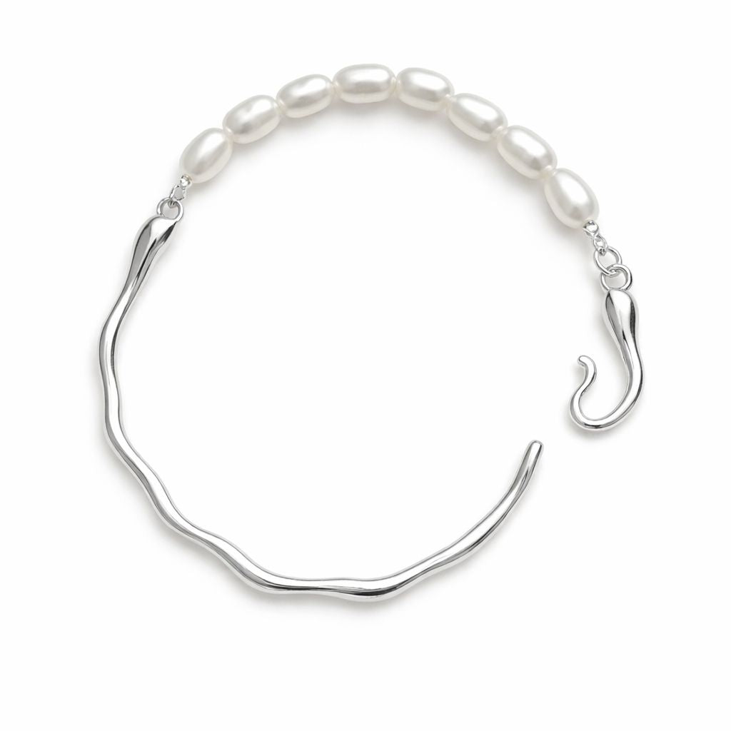 Silver bracelet with white pearls on a white background