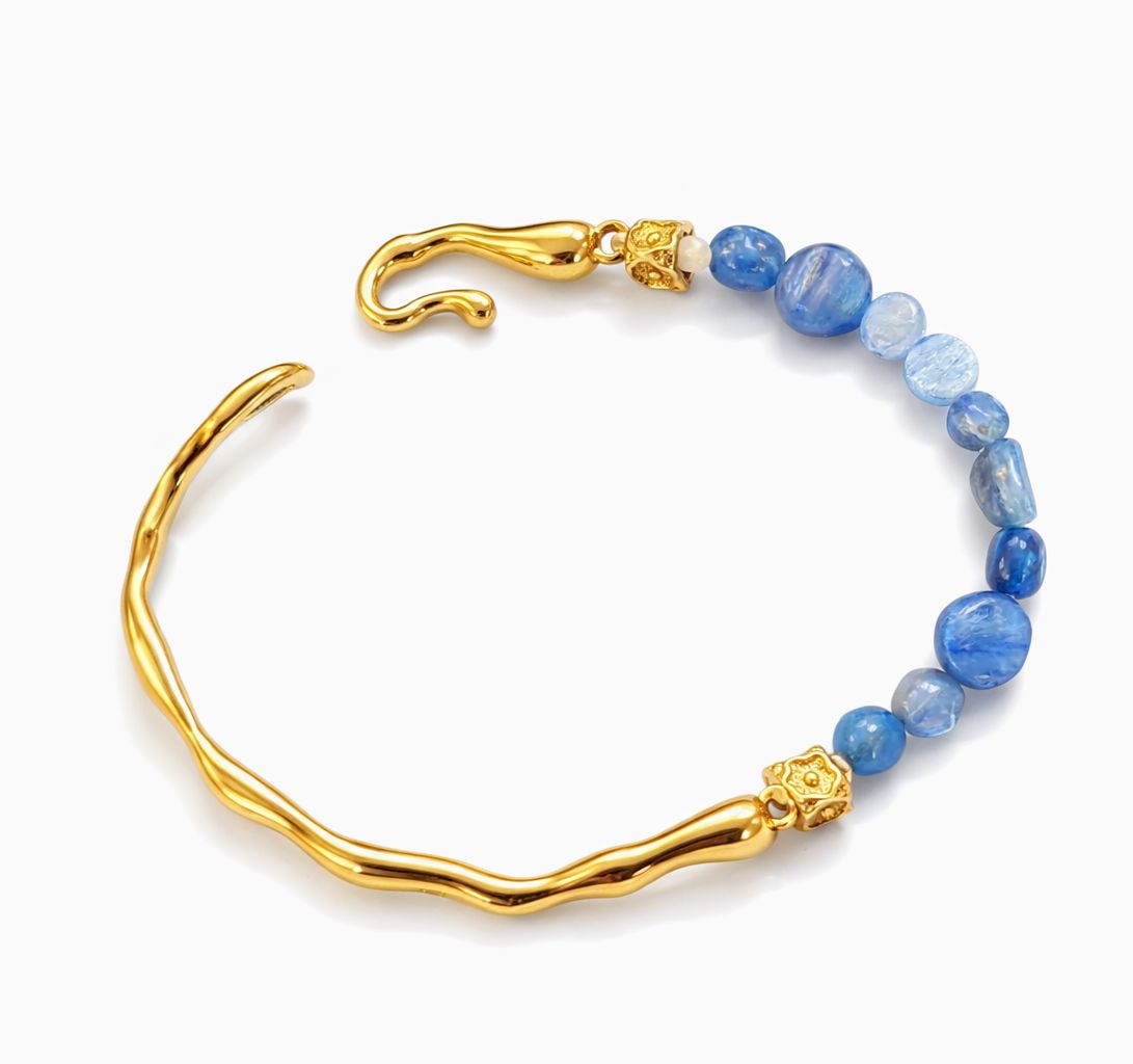 Gold bracelet with blue beads on a white background