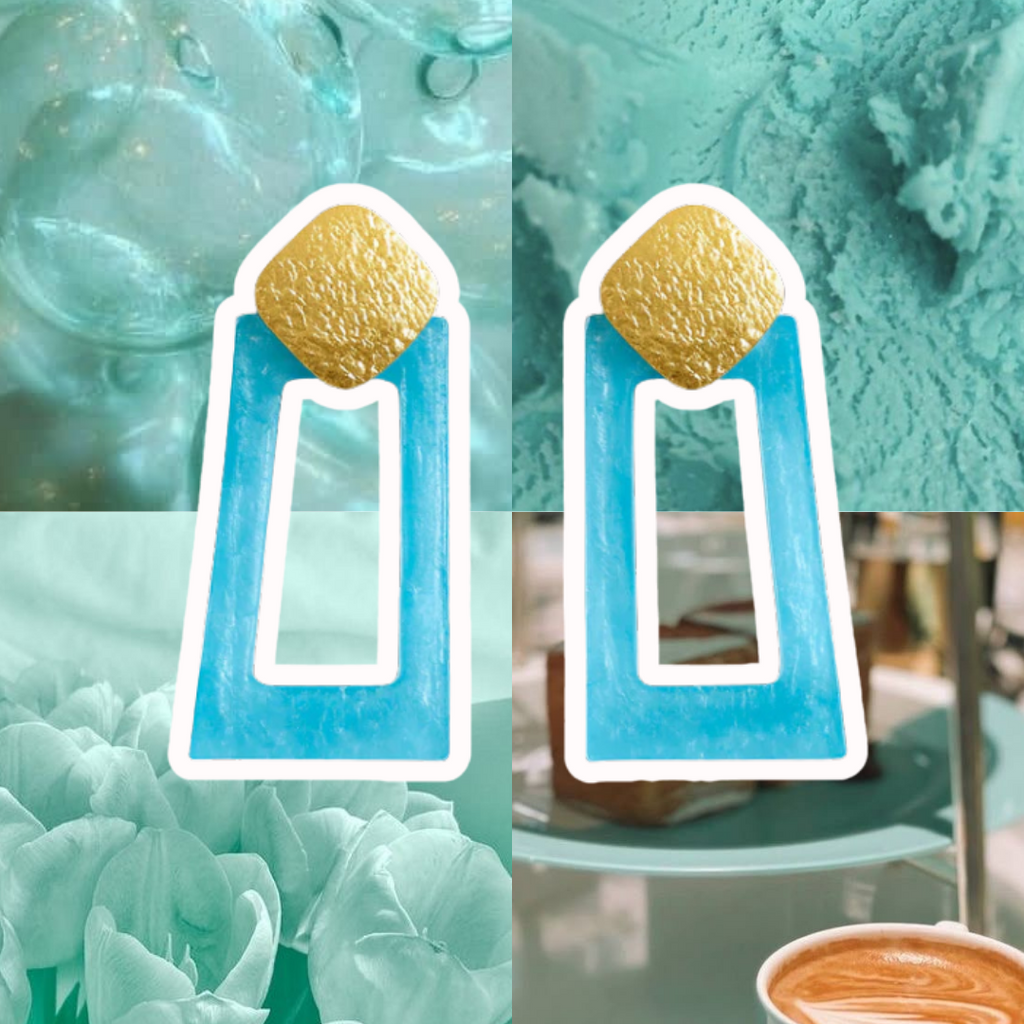 Pair of earrings with gold and blue design on a textured turquoise background