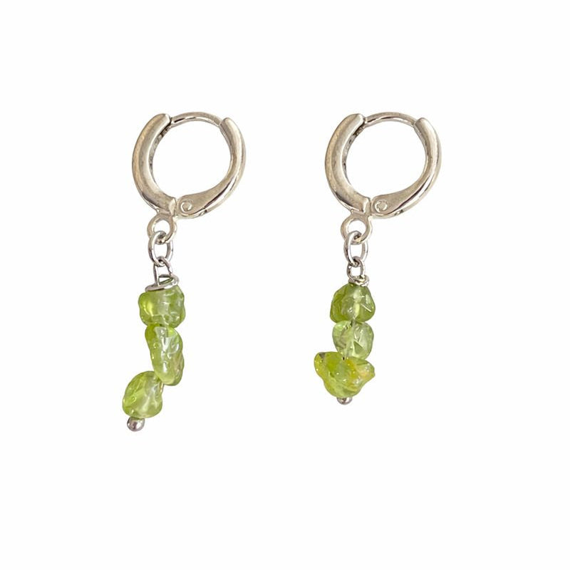 Pair of silver hoop earrings with green gemstone drops on a white background