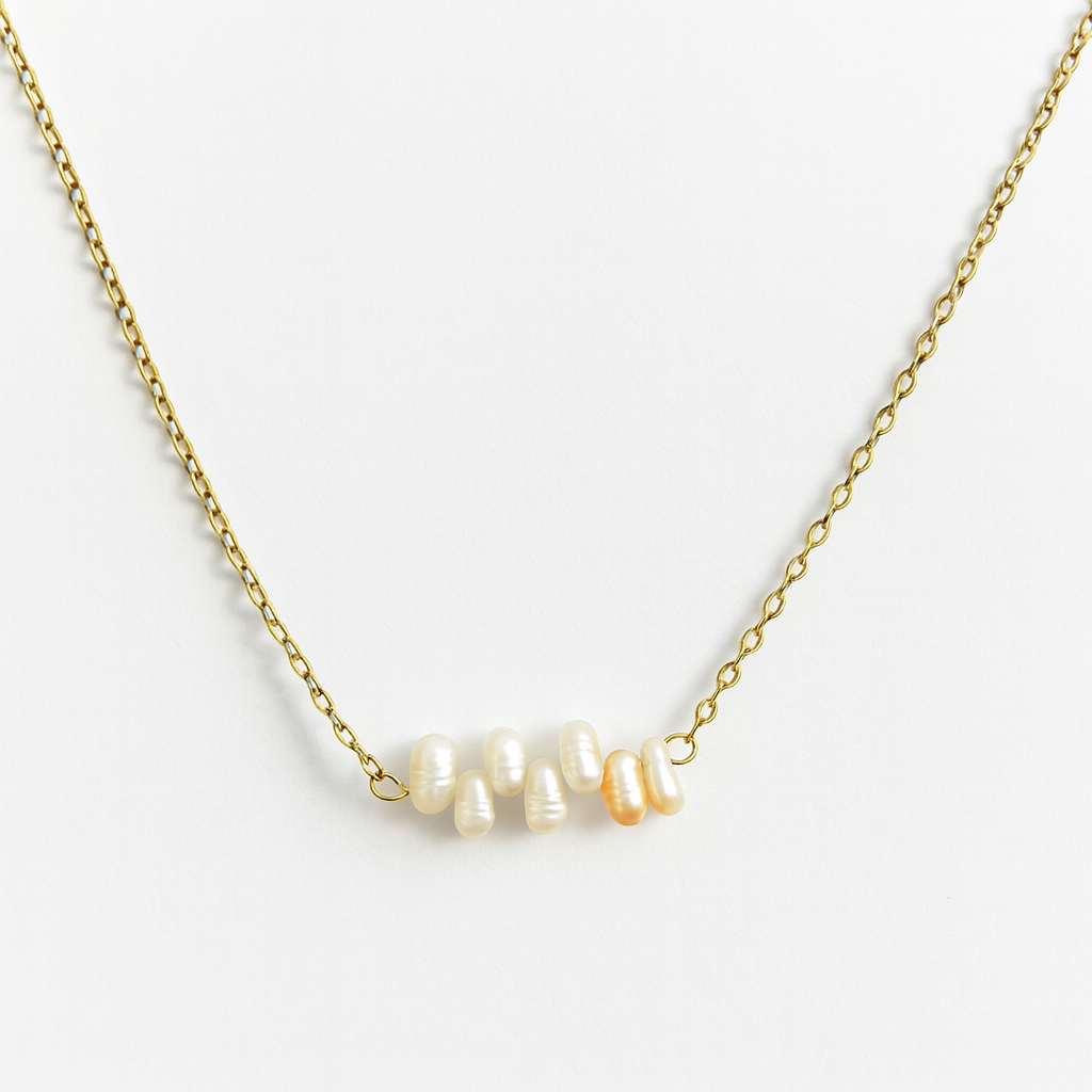 Gold necklace with pearls on a light gray background