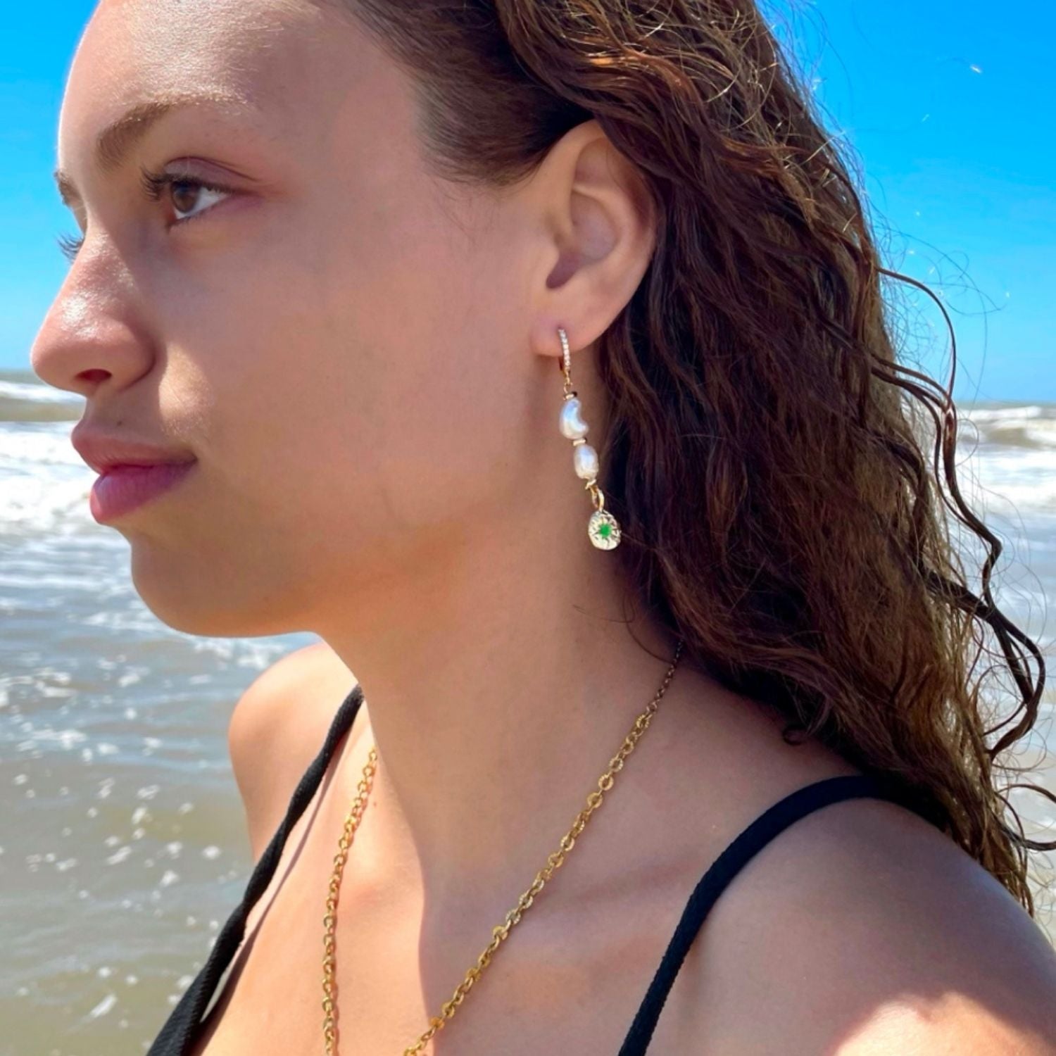 Woman wearing earrings with a beach background