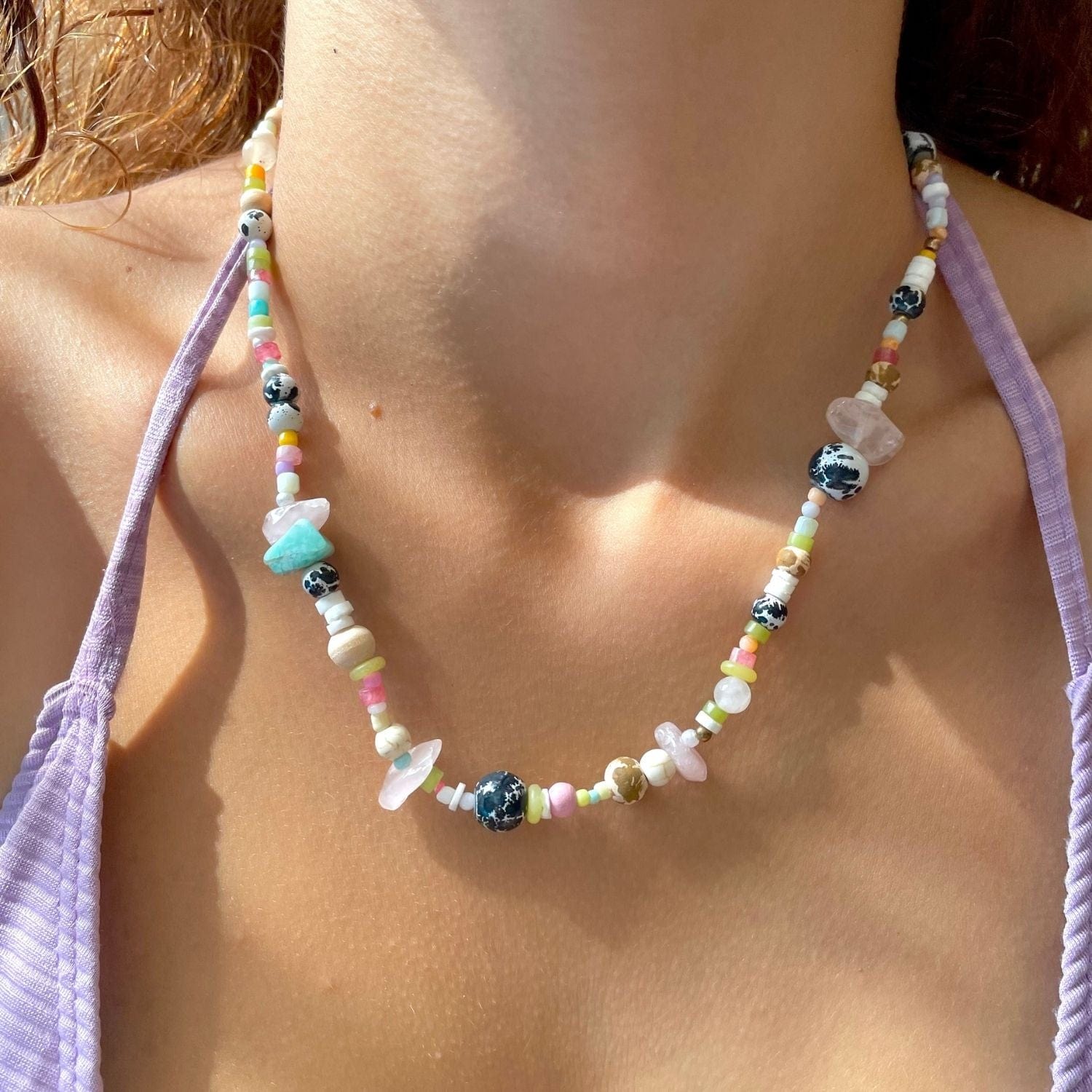 Colorful beaded necklace worn by a person with a blurred background
