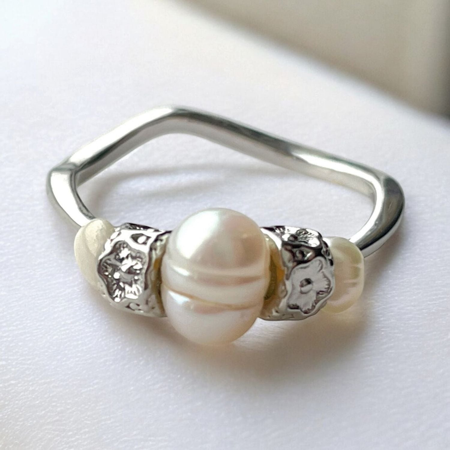 Silver ring with pearls on a white background