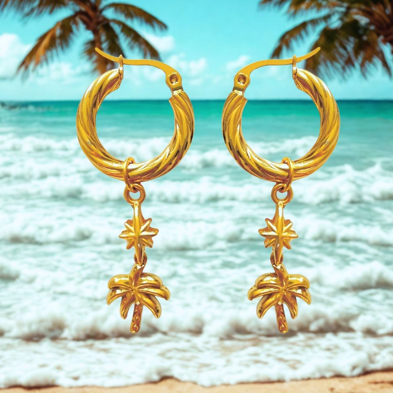 Gold hoop earrings with palm tree charms against a beach background