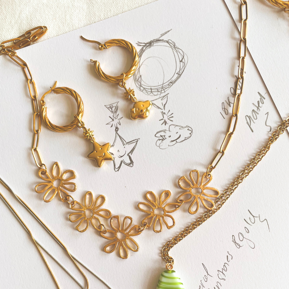 Gold and silver jewelry on a white surface with text