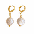 Gold hoop earrings with pearl drops on a white background
