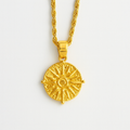 Gold necklace with a detailed pendant on a light gray background