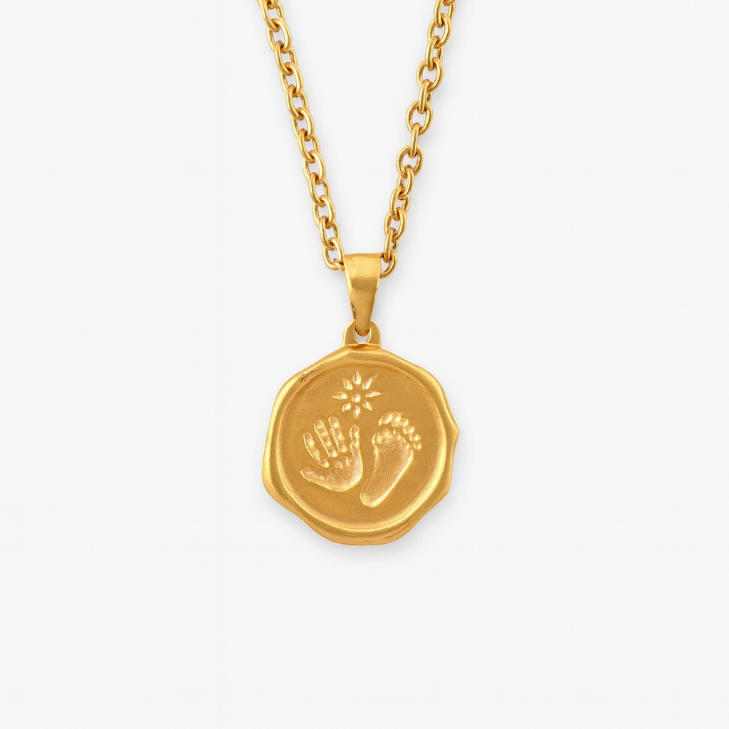 Gold necklace with a pendant featuring footprints and a sun design on a white background