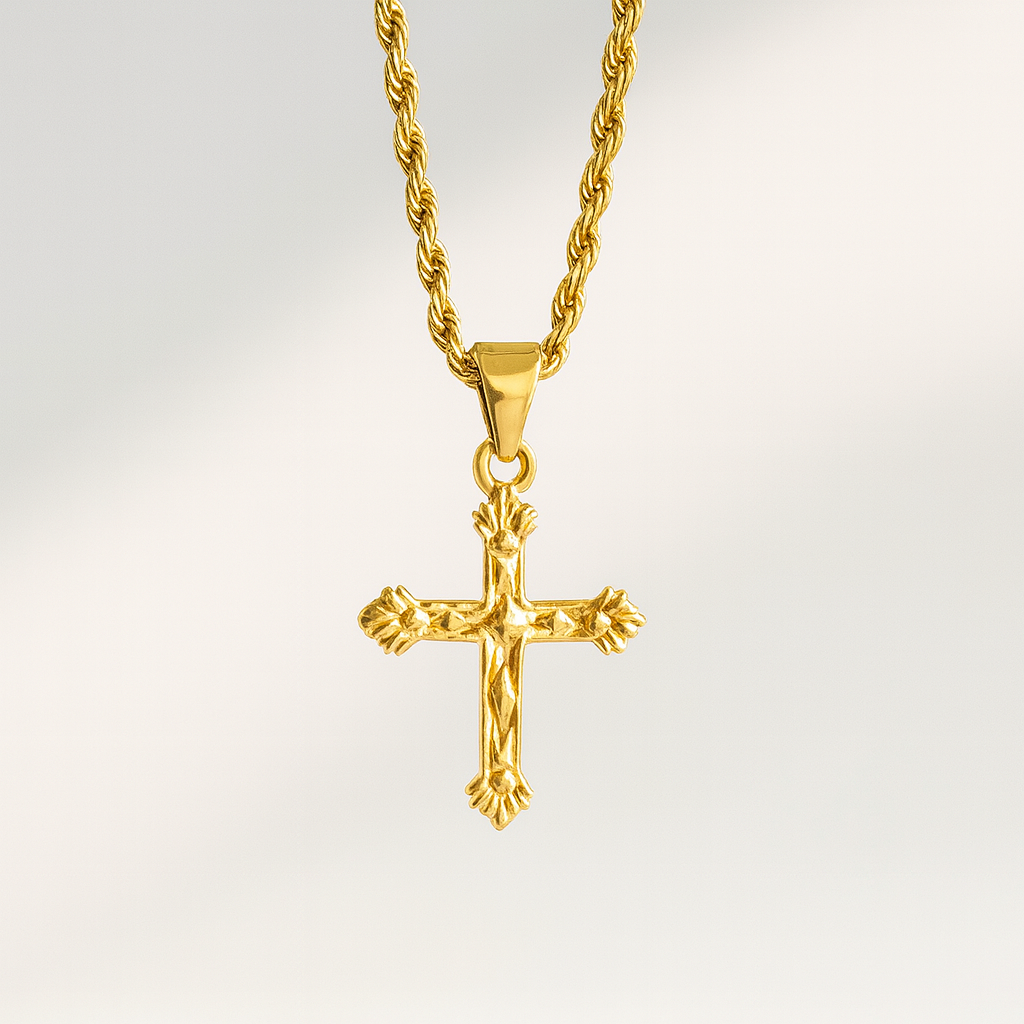 Gold cross pendant on a gold chain against a light gray background
