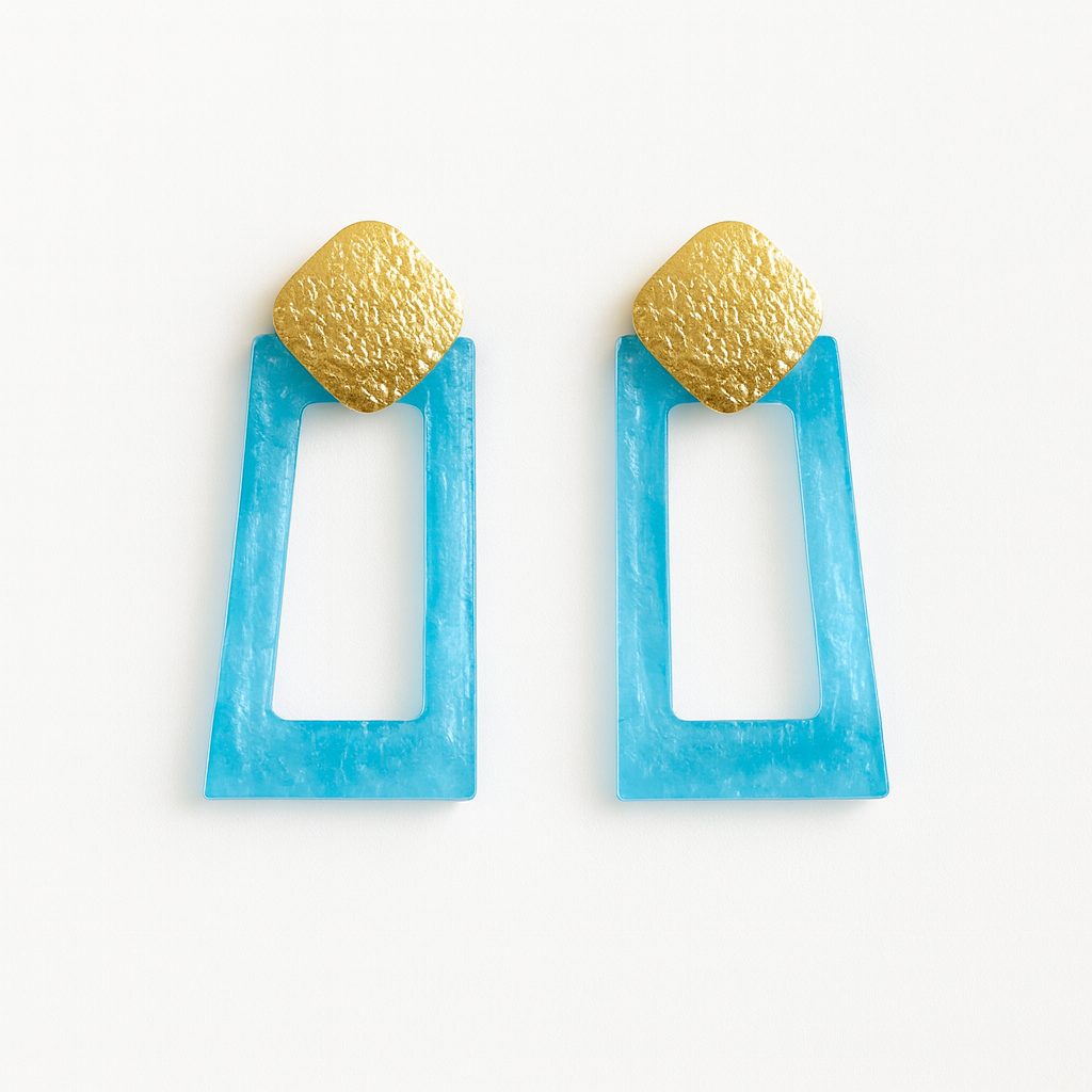 Pair of earrings with blue rectangular frames and gold spherical tops on a white background