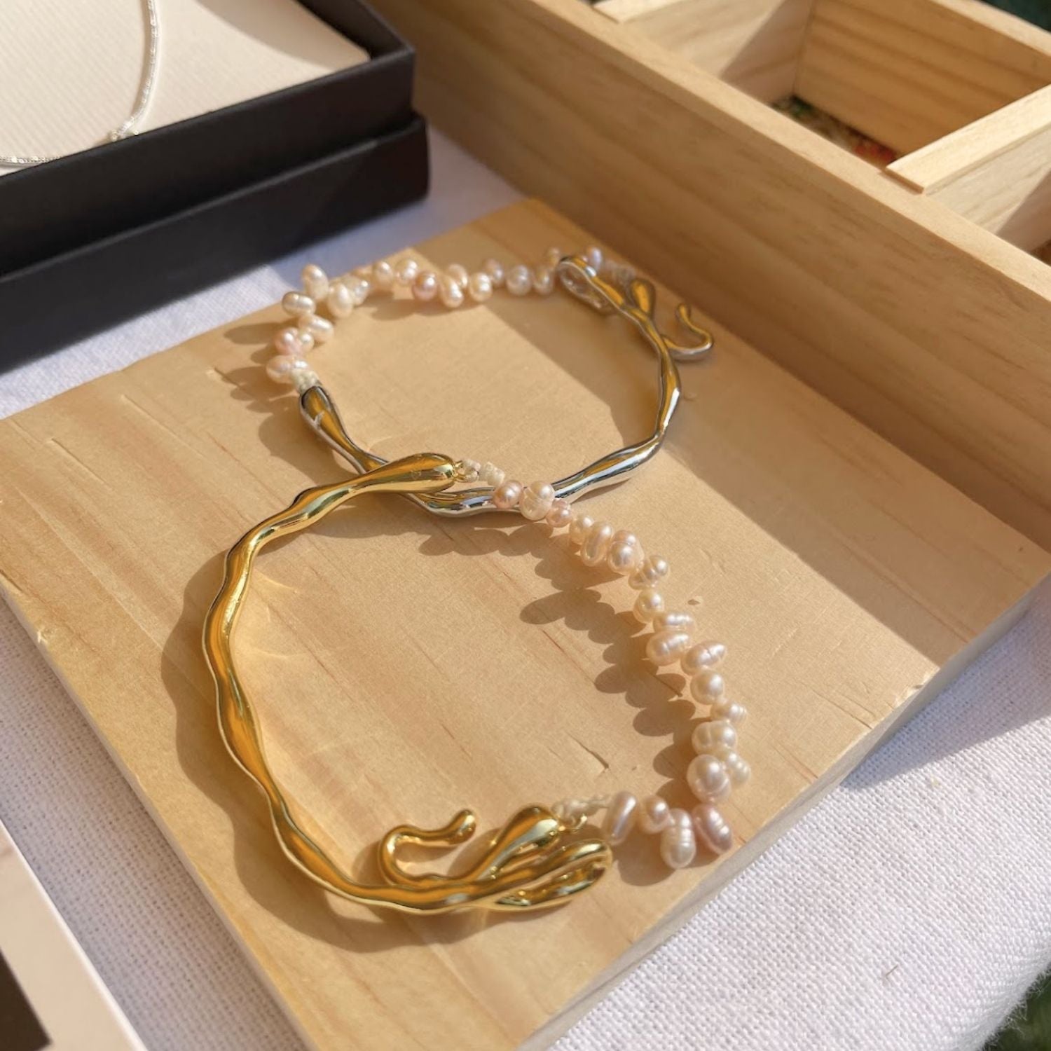 Gold and pearl necklace on a wooden surface