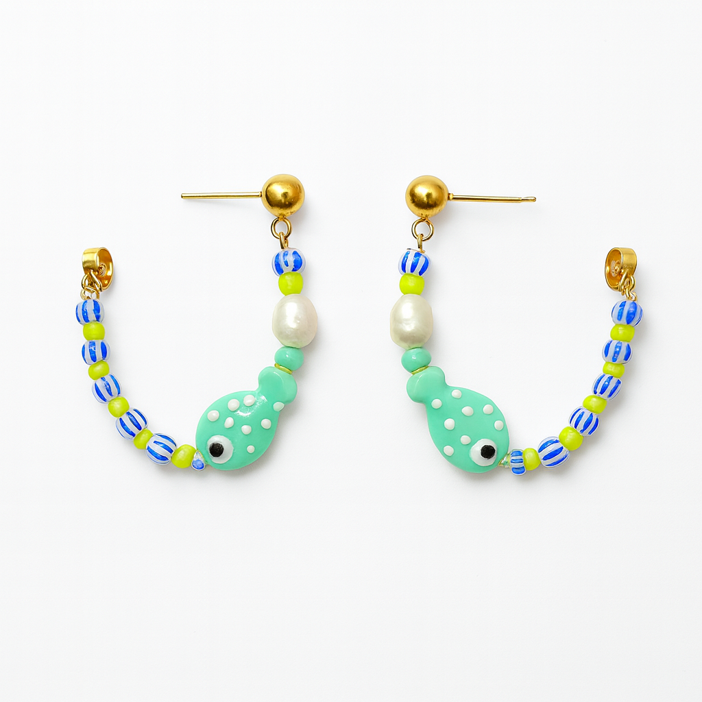 Pair of fish-shaped beaded earrings on a white background