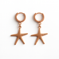 Rose gold starfish earrings on a white background