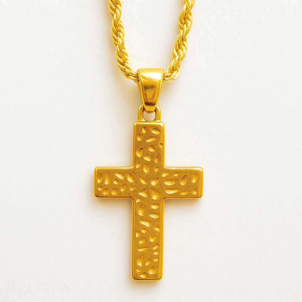 Gold cross pendant on a chain against a white background
