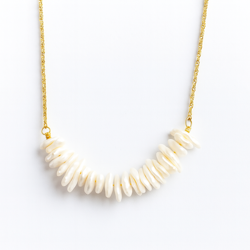Necklace with white shell beads on a gold chain against a white background
