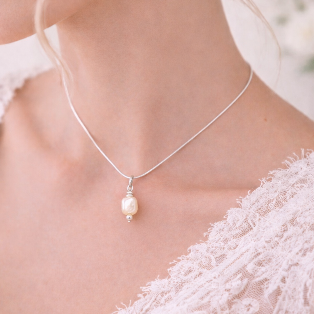 Pearl necklace worn by a person in a white lace garment