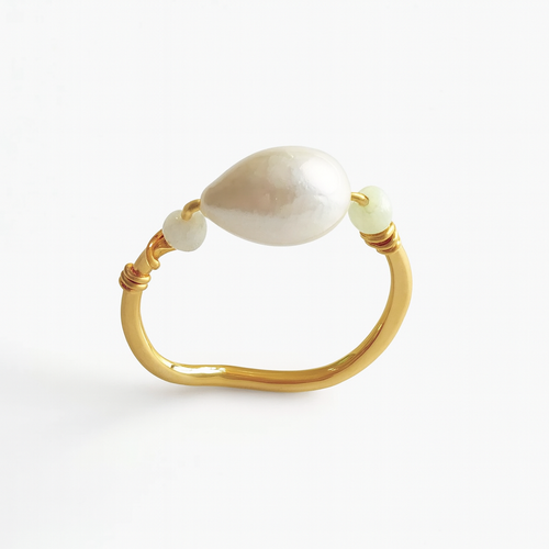 Gold ring with a large pearl and smaller beads on a white background
