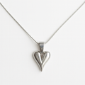 Silver heart-shaped pendant on a white chain against a white background
