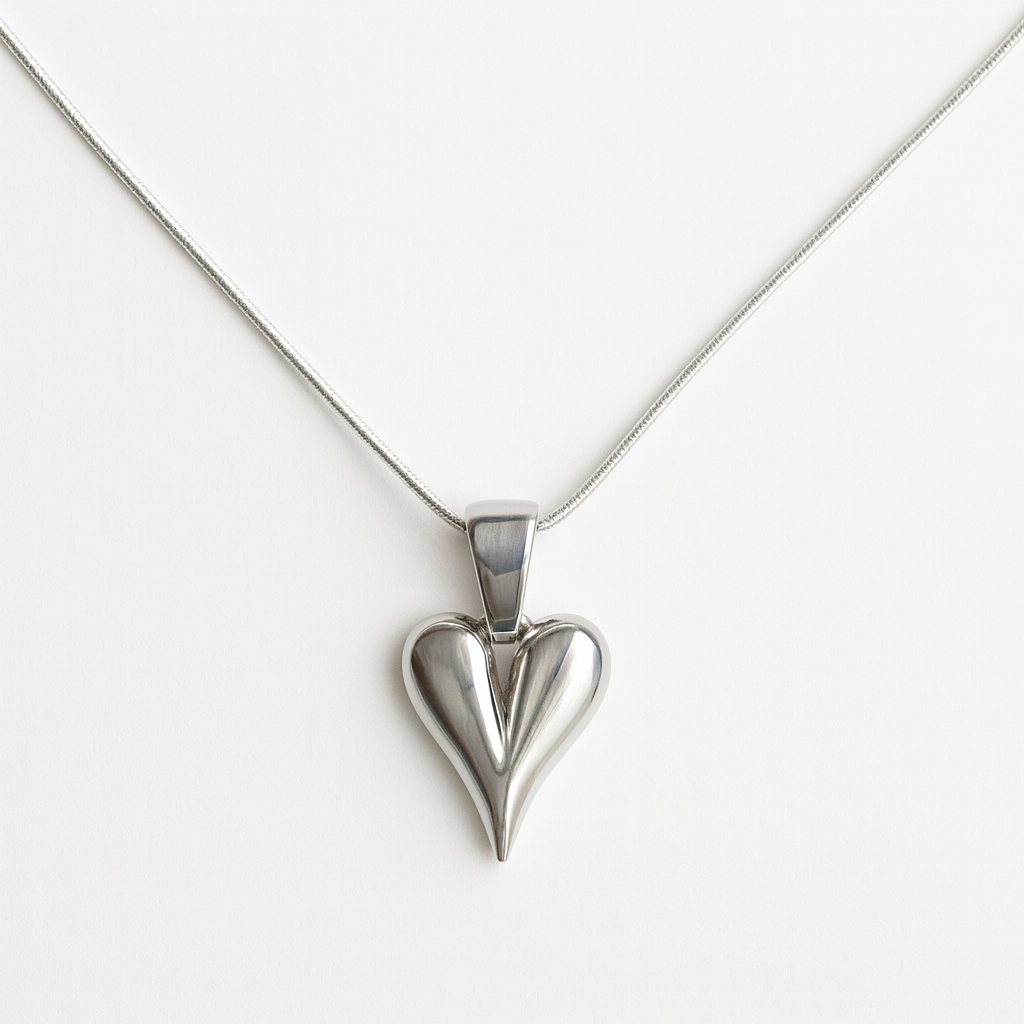 Silver heart-shaped pendant on a white chain against a white background