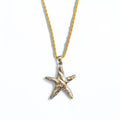 Gold starfish pendant on a gold chain against a white background